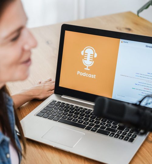 Mature woman live streaming podcast session at home studio - Focus on laptop computer screen